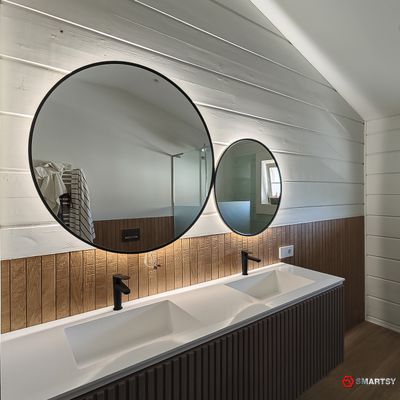 Круглое зеркало в черной рамке с интерьерной подсветкой.