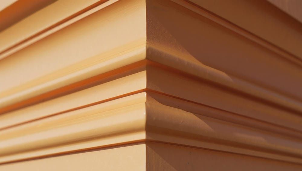 Детализированный дизайн фасада: полиуретановые молдинги и русты на стене коммерческого объекта.