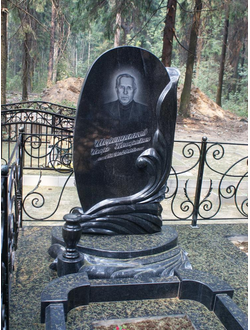 На фото круглый памятник на могилу для мужчины в СПб
