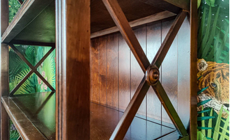 Стеллаж высокий с перекрестиями, на точеных ножках.