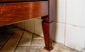 Тумба под раковину со столешницей из плитки с деревянным краем.