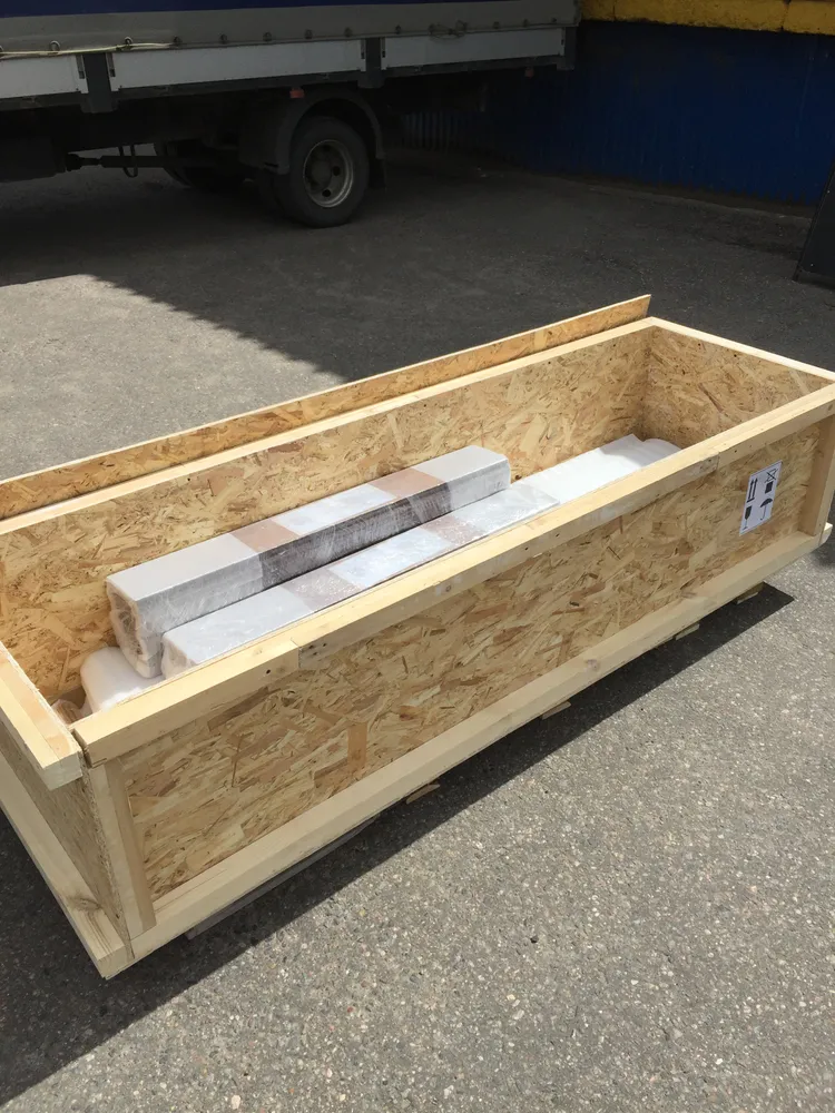 Пример жесткой упаковки, которую мы используем для перевозки стеновых панелей и штапика из массива дерева длиной 2,2 метра - изготовленный деревянный ящик, выставленный на паллеты.