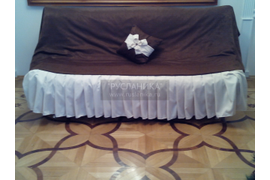 Декоративная подушка с бантом на диване.