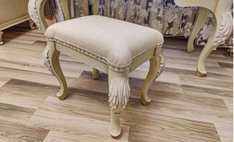 Пуф с мягким сиденьем на резных ножках.