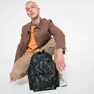 Парень держит в руках рюкзак Eastpak Padded Pak'r Leaves Dark