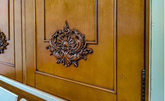 Шкаф для одежды с резным декором на фасадах и нижним ящиком.