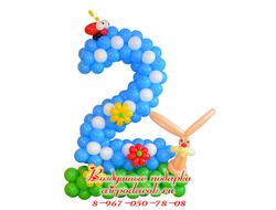 Цифра 2 из шаров, сплетённая из голубых шаров, стоящая на зеленой полянке, с забавным зайчиком