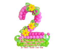 Нежно розовая цифра 2, стоящая на зеленом основании, украшенная желтыми цветами