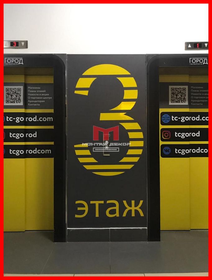 Пленка с плоттерной резкой на стене у лифта в ТЦ