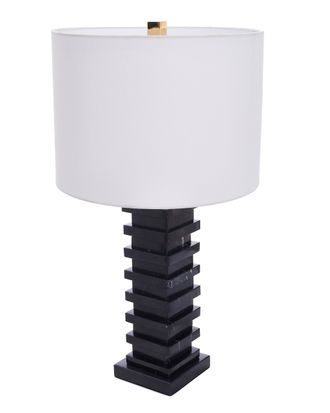 Настольная лампа из черного мрамора с белым цилиндрическим абажуром.