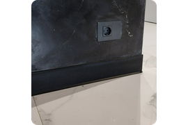 Монументальное решение: монтаж черного плинтуса Dollken S100 создает впечатляющий архитектурный акцент в интерьере, подчеркивая масштаб помещения и его величественность.