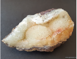 Кальцит на окисленной породе с пиритовой присыпкой. Россия.