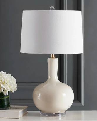 Настольная лампа из дутого непрозрачного стекла кремового цвета с белым абажуром.