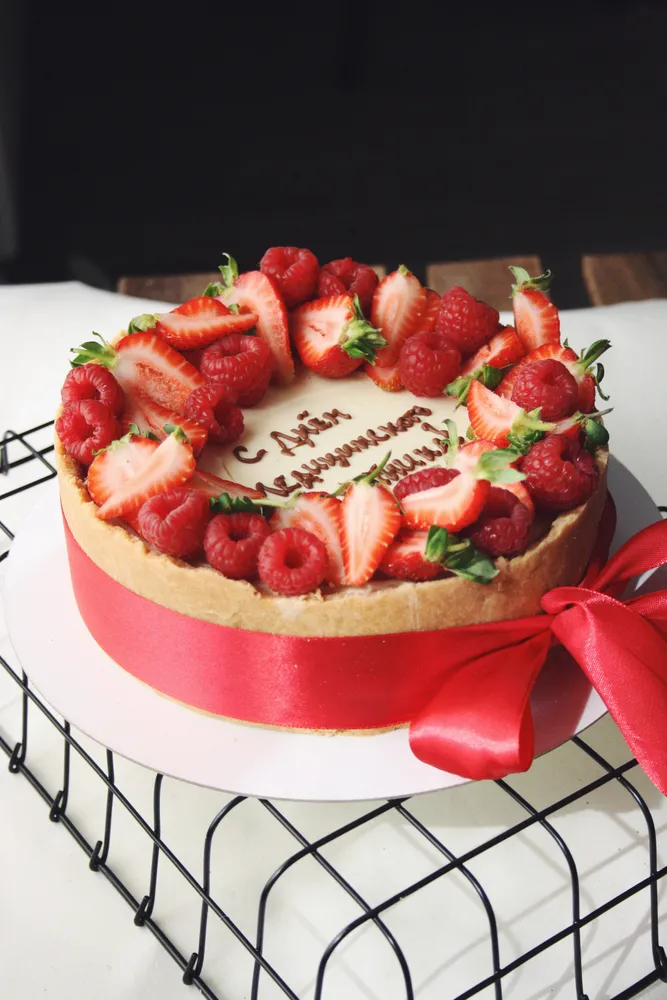 Чизкейк классический с венком из ягод и надптсью шоколадом