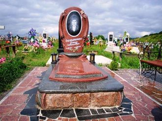 На фото круглый памятник на могилу в форме свитка в СПб