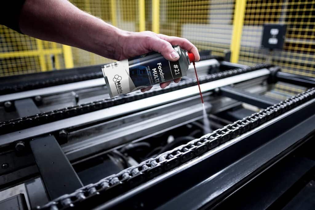 Нанесение пищевой смазки с PTFE Matrix Foodmax Multi Spray на конвейерную цепь в производстве.