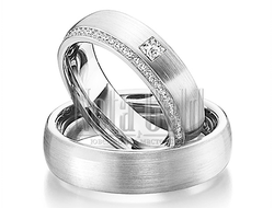 Обручальные кольца из белого золота с дорожкой бриллиантов и одним крупным в женском кольце широкие