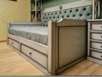 Кровать в виде тахты, с двумя выдвижными ящиками и верхней и боковой надстройкой.