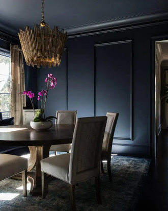 Люстра из нерегулярно расположенных деревянных прутьев в золотом цвете.