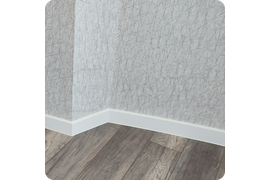 Функциональный дизайн: монтаж гибкого белого плинтуса Dollken Cubu Flex Life 100 с возможностью адаптации к любой форме помещения.