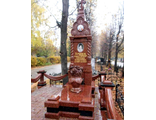 Памятник из красного гранита оригинальной формы в виде часовни