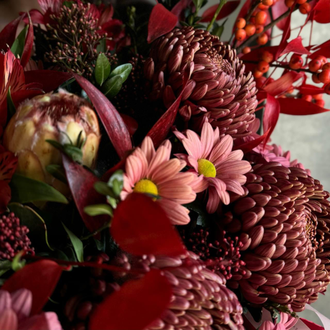 КОМПОЗИЦИЯ В ПЛЕТЕННОМ КАШПО С ПИОНОВИДНЫМИ РОЗАМИ, СЕЗОННЫМИ ХРИЗАНТЕМАМИ БИГУДИ И ЯРКИМИ ОСЕННИМИ ЛИСТЯМИ - (АРТ. К64)