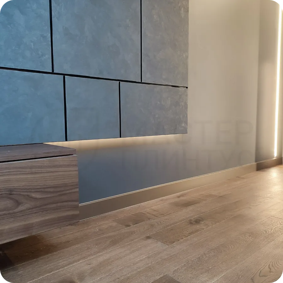 Изысканное обрамление: установка бронзового плинтуса создает утонченное обрамление пространства с современным металлическим характером.