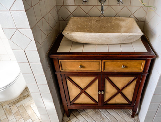 Тумба под раковину со столешницей из плитки с деревянным краем.