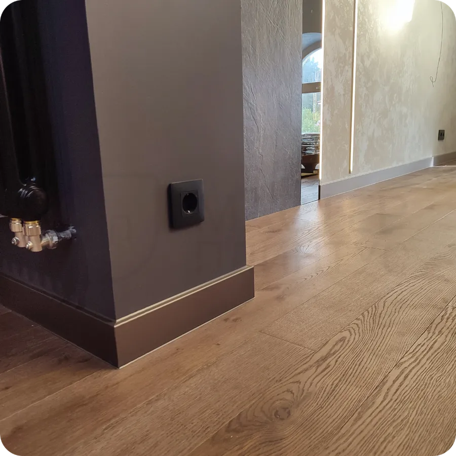 Металлическая утонченность: установка бронзового плинтуса демонстрирует утонченность металлического дизайна в современном интерьере.