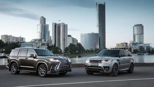 Как выбрать премиальный кроссовер для аренды: Lexus LX и Range Rover на фоне городской набережной