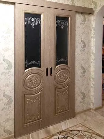 Дверь раздвижная под проем 1300*2000. Две створки в цвете "сандал" и с узорчатым матовым стеклом. Патинирование в цвет "шампань".