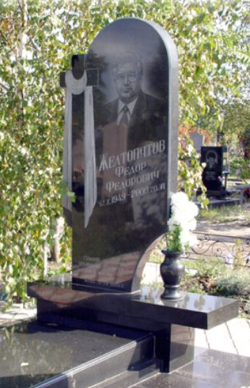 На фото круглый памятник на могилу с большим крестом в СПб