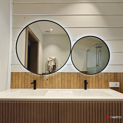 Круглое зеркало в черной рамке с интерьерной подсветкой.